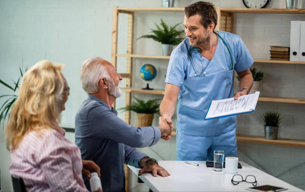 A healthcare provider greets an older patient with a handshake during a consultation, illustrating trust, communication, and choosing the right skilled nursing care.